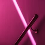 a pink wall with a metal handle on it